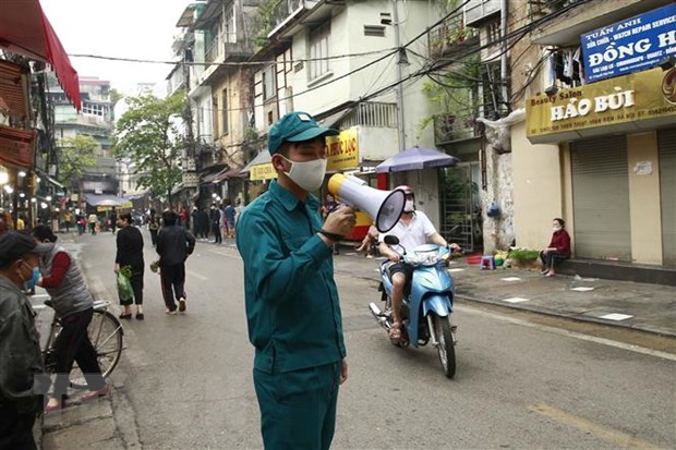 Các lực lượng chức năng làm nhiệm vụ giãn cách xã hội tại phố Nguyễn Thiện Thuật, phường Đồng Xuân, quận Hoàn Kiếm. (Ảnh: Doãn Tấn/TTXVN)