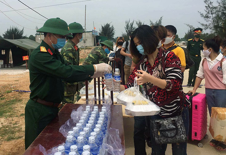 Cán bộ Ban Chỉ huy Quân sự thị xã Ba Đồn cấp phát bữa trưa cho các công dân trước khi lên xe về địa phương.