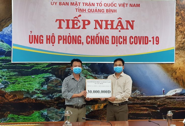 Đại diện lãnh đạo Sở Gáo dục-Đào tạo trao tiền ủng hộ phòng chống dịch cho Ủy ban MTTQVN tỉnh.