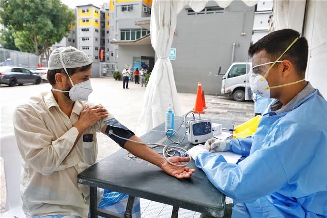 Lao động nước ngoài được kiểm tra y tế tại Singapore ngày 8-4-2020. Ảnh: THX/TTXVN
