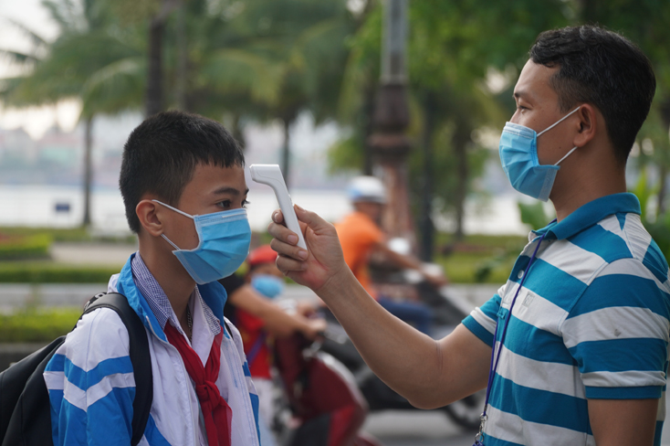  Đo thân nhiệt cho HS trước khi vào trường học.