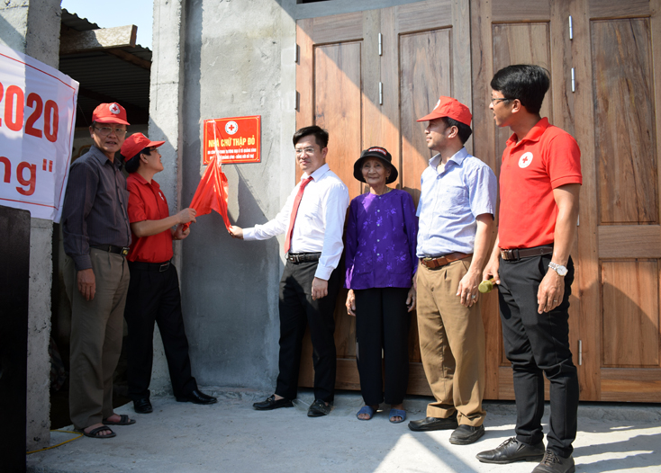 Các đại biểu kéo băng khánh thành nhà Chữ thập đỏ cho gia đình bà Phạm Thị Hồng đưa vào sử dụng