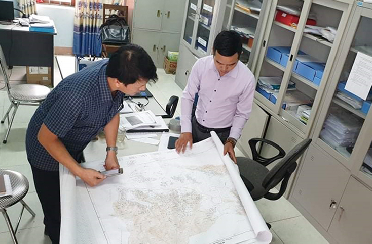 Cán bộ địa chính xã Quảng Hợp trao đổi với phóng viên Báo Quảng Bình về hiện trạng đất đai trên địa bàn.