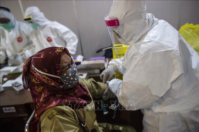 Nhân viên y tế lấy mẫu xét nghiệm COVID-19 tại Surabaya, Indonesia, ngày 11/5/2020. Ảnh: AFP/TTXVN