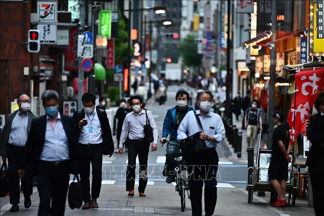  Người dân di chuyển trên một đường phố ở Tokyo, Nhật Bản, ngày 15-5. Ảnh: AFP/TTXVN