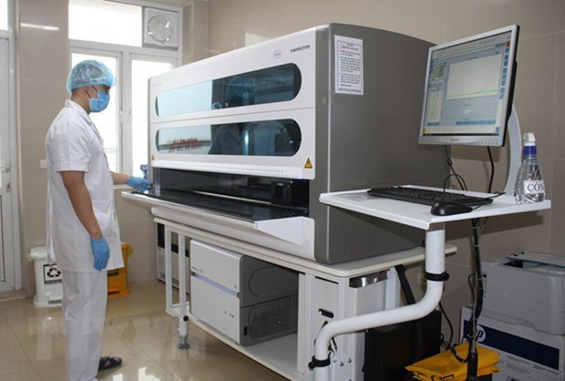  Cán bộ y tế xét nghiệm mẫu trên máy xét nghiệm Real-time PCR. (Ảnh: TTXVN)