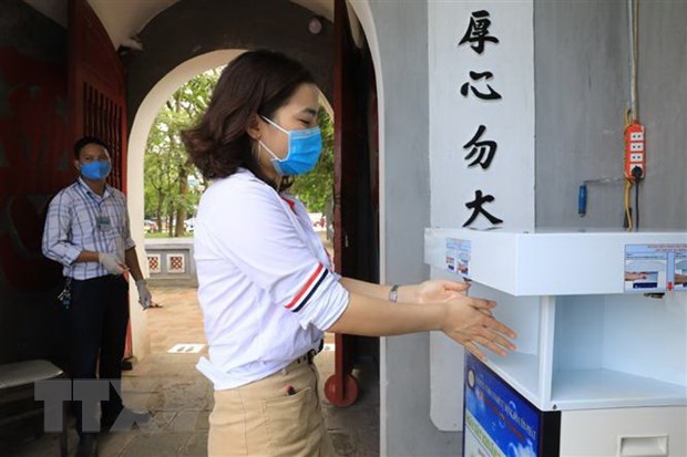 Du khách rửa tay sát khuẩn trước khi vào thăm quan Di tích Đền Ngọc Sơn-Tháp Bút. (Ảnh: Thành Đạt/TTXVN)