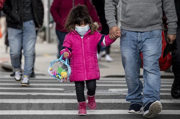  Một em nhỏ đeo khẩu trang phòng dịch COVID-19. (Ảnh: AFP/TTXVN)
