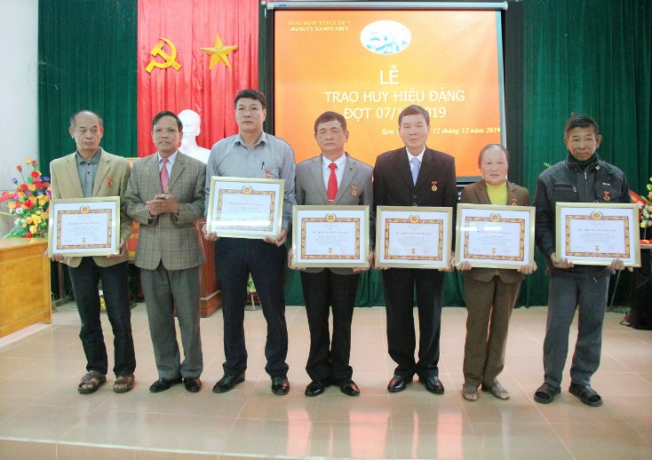   Đồng chí Nguyễn Văn Mọn, Huyện ủy viên, Bí thư Đảng ủy xã Sơn Thủy trao huy hiệu Đảng cho các đảng viên. 