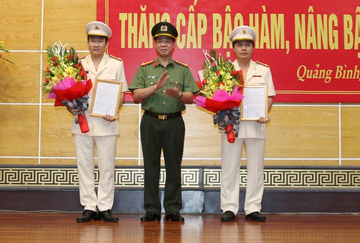 Đồng chí Đại tá Trần Hải Quân trao quyết định của Bộ trưởng Bộ Công an hăng cấp bậc hàm từ Thượng tá lên Đại tá cho 2 đồng chí Phó giám đốc Công an tỉnh.