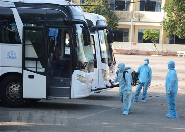 Nhân viên y tế phun thuốc khử trùng vào xe chở công dân từ Hàn Quốc trở về. (Ảnh: Văn Dũng/TTXVN)