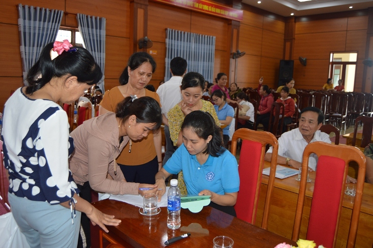 Cán bộ BHXH tỉnh hướng dẫn người dân ở xã Bảo Ninh (TP. Đồng Hới) các thủ tục tham gia BHXH tự nguyện.