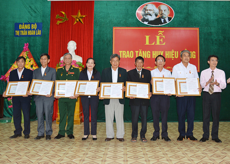 Đồng chí Bí thư Đảng ủy thị trấn Hoàn Lão Nguyễn Anh Đông trao huy hiệu Đảng cho các đảng viên. 