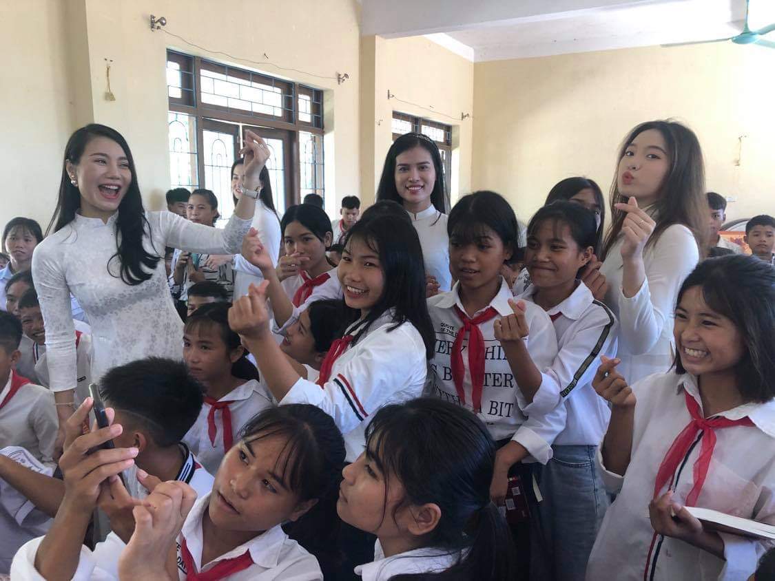Các người đẹp giao lưu, chụp ảnh lưu niệm với các em học sinh người dân tộc Bru-Vân Kiều