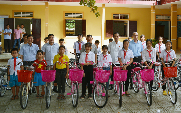 Các đồng chí: Trần Công Thuật, Nguyễn Ngọc Phương và đại diện lãnh đạo huyện Bố Trạch trao xe đạp cho các học sinh có hoàn cảnh khó khăn.