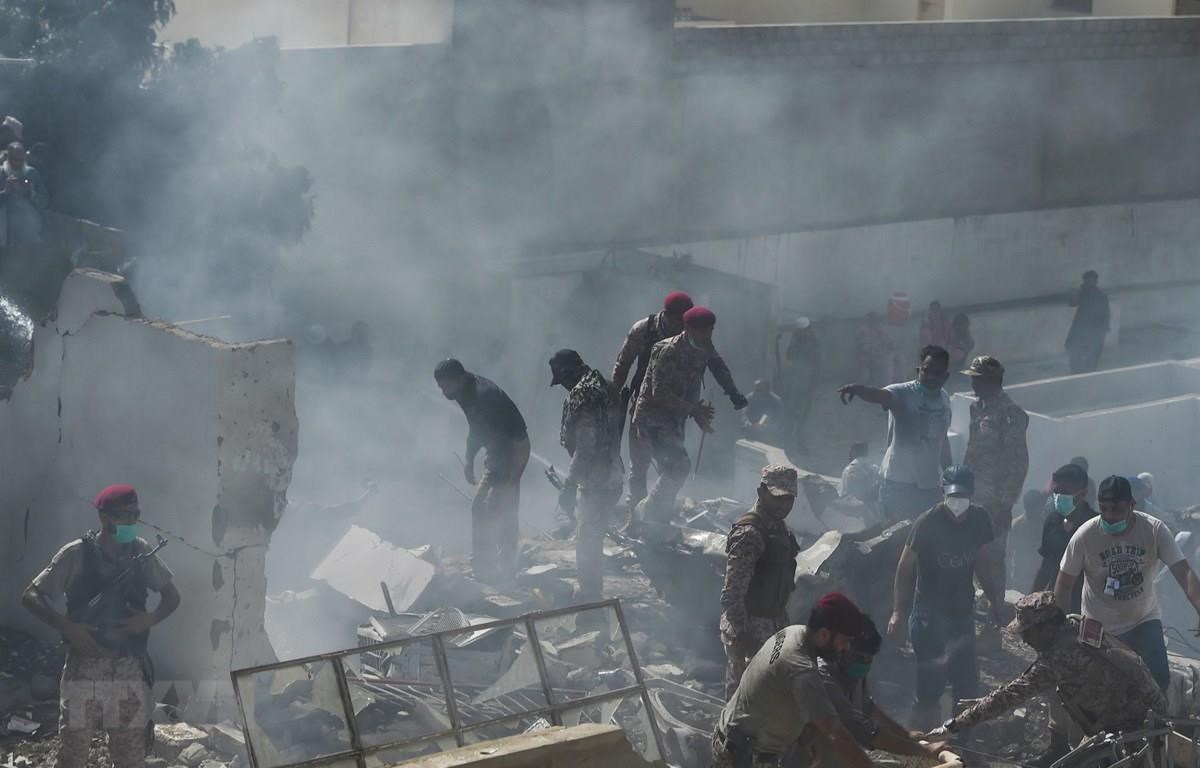 Lực lượng cứu hộ tìm kiếm nạn nhân tại hiện trường vụ rơi máy bay ở Karachi, Pakistan. (Ảnh: AFP/TTXVN)