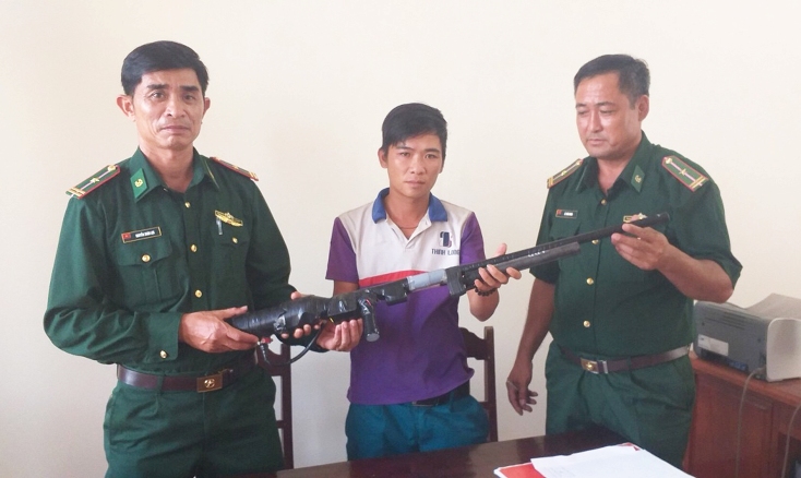 Cán bộ Đồn Biên phòng Ngư Thủy tiếp nhận súng tự chế từ anh Nguyễn Quốc Toản 