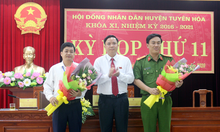 Ông Phạm Tiến Nam, Chủ tịch HĐND huyện Tuyên Hóa tặng hoa chúc mừng 2 đồng chí Ủy viên UBND huyện được bầu bổ sung.