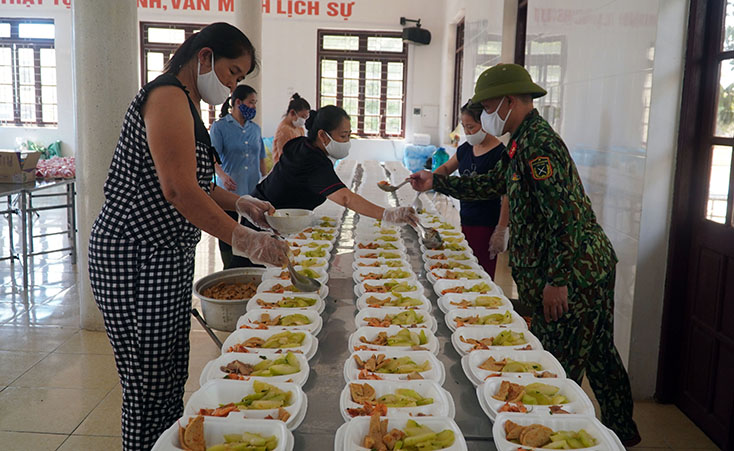 Cán bộ, chiến sĩ và lực lượng tình nguyện chuẩn bị bữa trưa cho sinh viên Lào