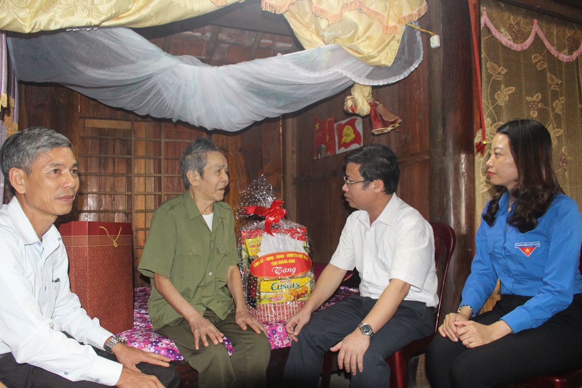 : Đồng chí Trưởng Ban Tuyên giáo Tỉnh ủy ân cần thăm hỏi thương binh Cao Văn Chuyên ở thôn 1 Kim Bảng, xã Minh Hóa, huyện Minh Hóa.