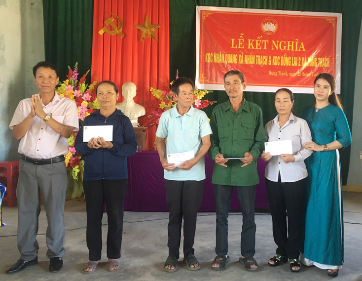 Đại diện Quỹ tín dụng nhân dân xã Nhân Trạch tặng quà cho các gia đình chính sách ở thôn Bồng Lai 2 xã Hưng Trạch. 