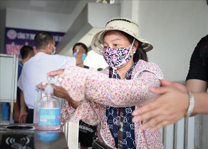 Người dân cần tích cực thực hiện đeo khẩu trang, vệ sinh tay để phòng tránh virus SARS-CoV-2. Ảnh: TTXVN