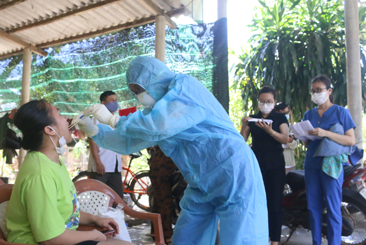 Cán bộ Trung tâm Kiểm soát bệnh tật tỉnh trực tiếp lấy mẫu xét nghiệm cho người dân về từ vùng dịch Đà Nẵng tại xã Vạn Ninh (Quảng Ninh) vào trưa 29-7.