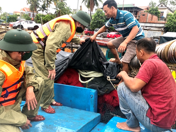 Tổ công tác đồn BP Nhật Lệ giúp ngư dân chằng chống bão.
