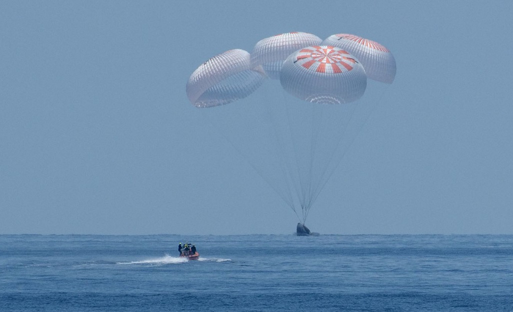 Một chiếc tàu nhanh của SpaceX chạy về phía phi thuyền Crew Dragon chở theo hai phi hành gia NASA trước khi nó hạ cánh xuống vịnh Mexico. Ảnh: NASA TV