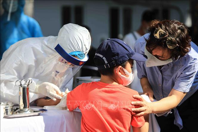  Nhân viên y tế lấy mẫu máu test nhanh cho các công dân trở về từ Đà Nẵng. Ảnh: Thành Đạt/TTXVN