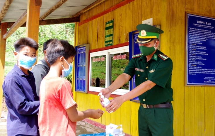  Cán bộ trạm kiểm soát cửa khẩu phụ Cà Ròong - Noọng Ma (Lào) đồn Biên phòng Cà Ròong phát khẩu trang miễn phí và rửa tay sát khuẩn cho người dân qua lại cửa khẩu.