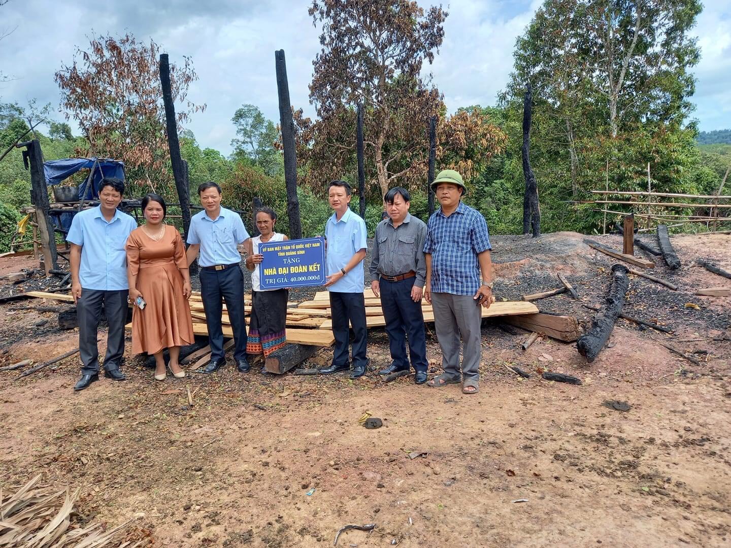 Mặt trận TQVN tỉnh và huyện Minh Hóa trao tiền hỗ trợ gia đình bà Hồ Thị Kiêng dựng lại nhà.(ảnh: Thùy Linh)