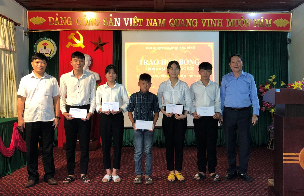 Đại diện Hội khuyến học tỉnh và Ủy ban MTTQ huyện Minh Hóa trao học bỏng cho các em học sinh ở Trường THPT Minh Hóa.