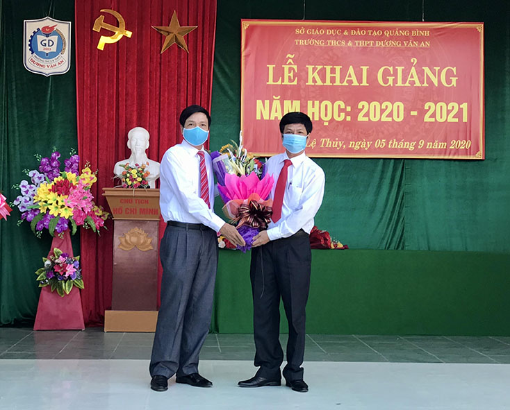 Đồng chí Phó Chủ tịch Thường trực HĐND tỉnh Nguyễn Công Huấn tặng hoa cho đại diện lãnh đạo Trường THCS và THPT Dương Văn An