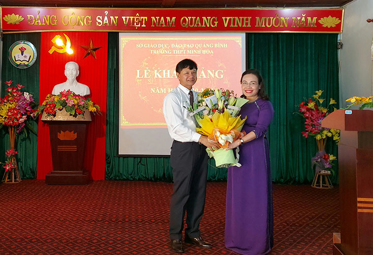 Đồng chí Phạm Thị Hân tặng hoa chắc mừng tập thể sư phạm Trường PTTH Minh Hóa.