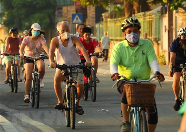 Người dân đeo khẩu trang tập thể dục sáng sớm trên phố Trích Sài, Tây Hồ. (Ảnh: Lâm Khánh/TTXVN)