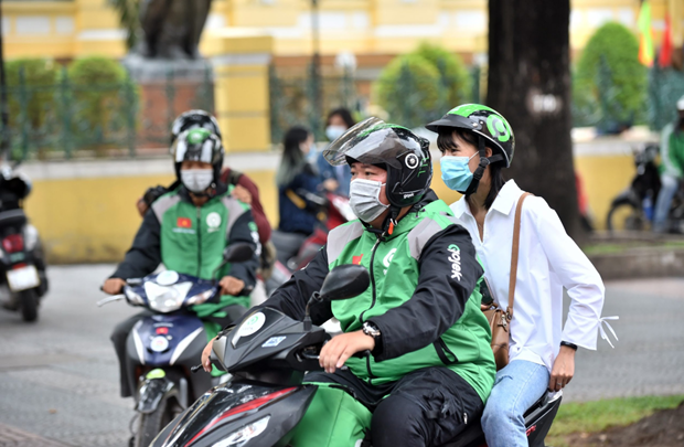  Hành khách luôn đội mũ bảo hiểm, ngồi xe đúng quy cách và bảo quản tài sản cá nhân. (Ảnh: PV/Vietnam+)