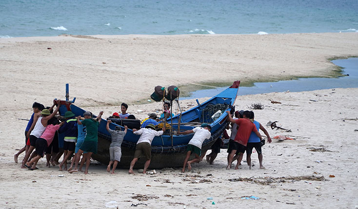 Người dân xã Ngư Thủy (Lệ Thủy) đi chuyển tàu thuyền đến nơi an toàn  