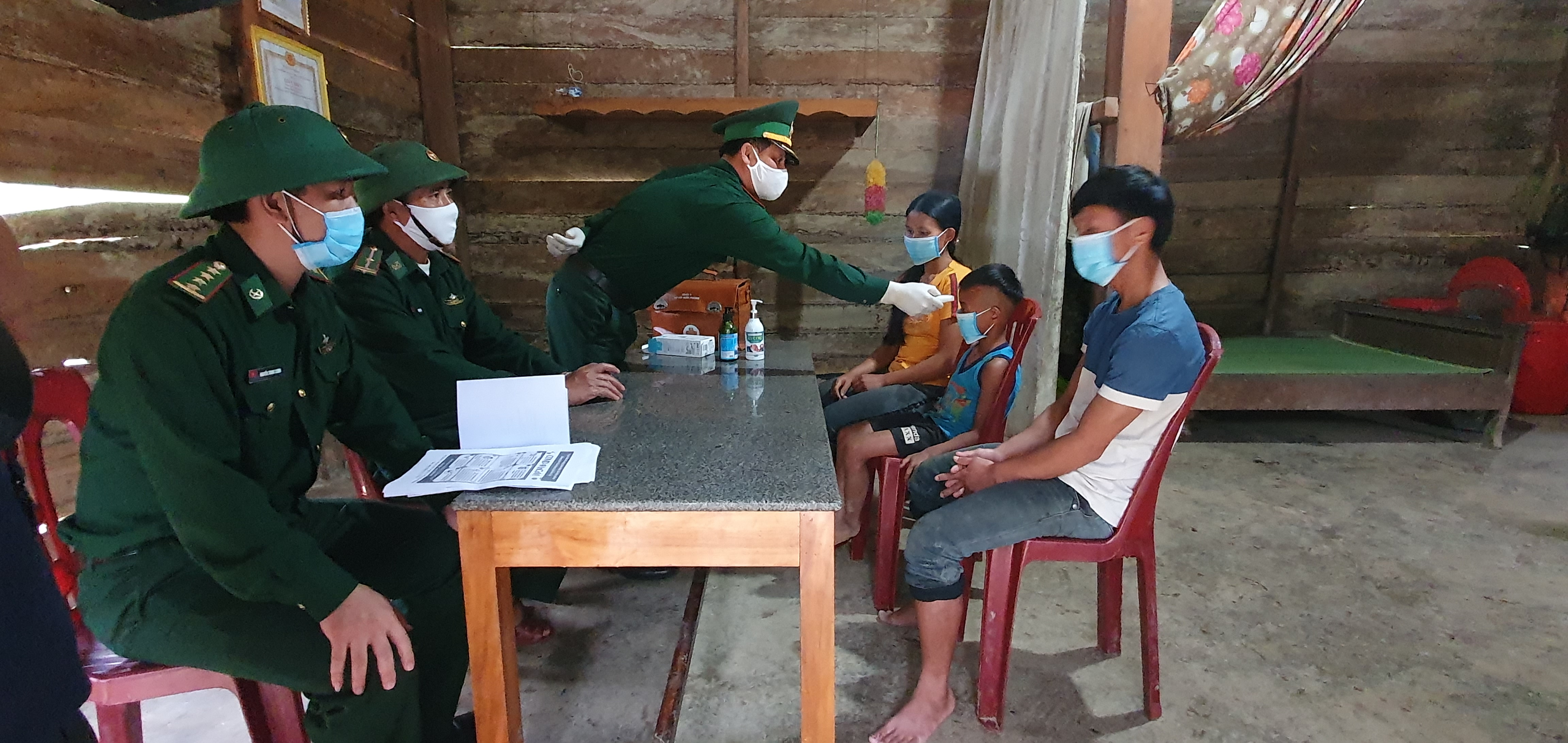  Các cán bộ, chiến sỹ Bộ đội Biên phòng hỗ trợ, hướng dẫn cho đồng bào dân tộc thiểu số huyện Minh Hóa cách phòng, chống dịch bệnh Covid-19. 
