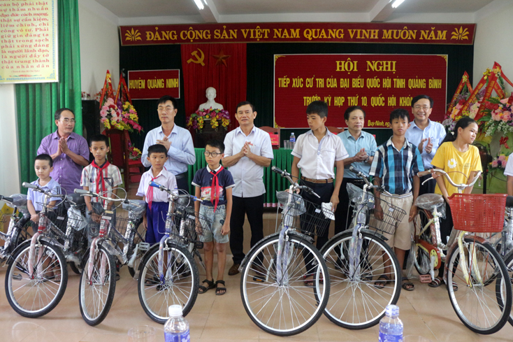 Đại diện tổ ĐBQH tỉnh và lãnh đọa huyện Quảng Ninh trao tặng xe đạp cho học sinh nghèo vượt khó.