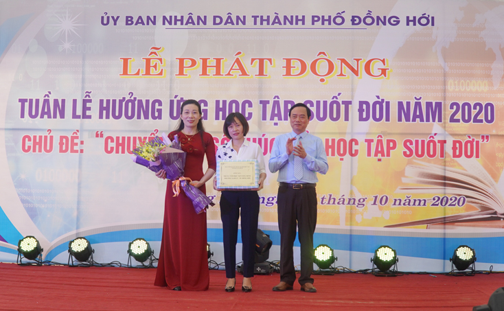 Giám đốc Sở GD-ĐT, Phó trưởng ban Thường trực Ban Chỉ đạo xây dựng XHHT tỉnh Đinh Quý Nhân tặng hoa, quà chúc mừng Trung tâm học tập cộng đồng phường Nam Lý.