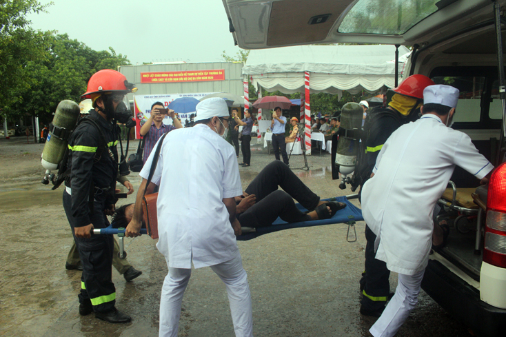 Lực lượng CNCH đưa người bị nạn ra khỏi hiện trường vụ cháy đến xe cứu thương
