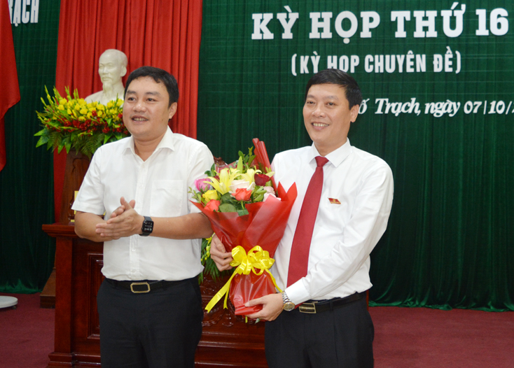 Đồng chí Đinh Hữu Thành, Tỉnh ủy viên, Bí thư Huyện ủy Bố Trạch tặng hoa chúc mừng đồng chí tân Chủ tịch UBND huyện Bố Trạch.