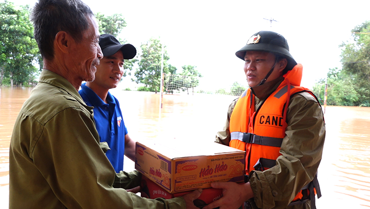Đại tá Bùi Quang Thanh, Phó Giám đốc Công an tỉnh Quảng Bình trao tặng mì tôm, nước uống cho người dân vùng ngập lụt.