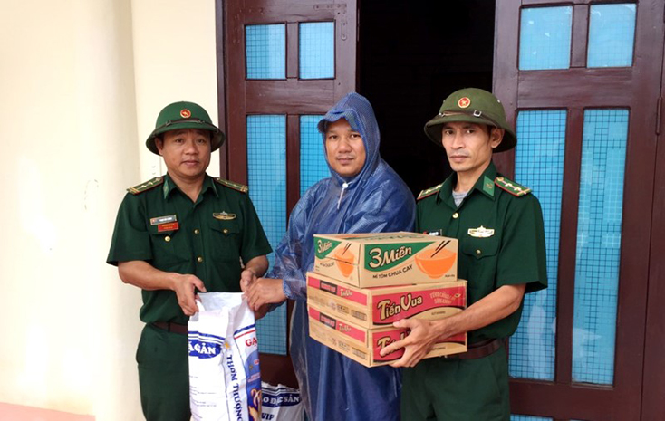 Cán bộ đồn Biên phòng Ra Mai, BĐBP Quảng Bình hỗ trợ lương thực, thực phẩm cho hộ gia đình khó khăn trong vùng lũ. 