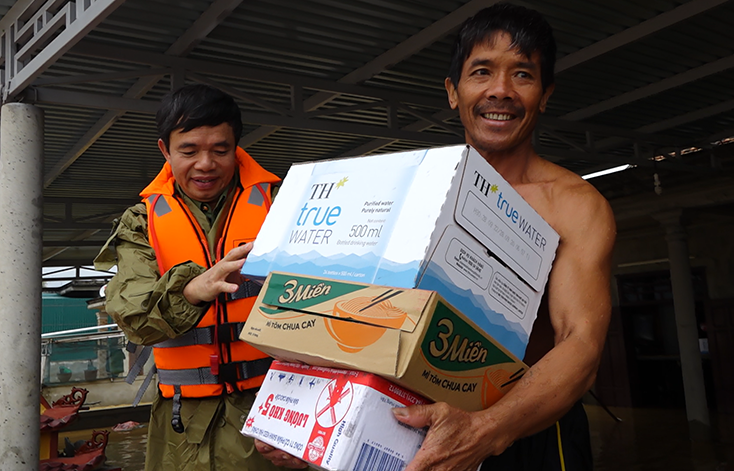 Đại tá Nguyễn Tiến Nam, UVTVTU, Giám đốc Công an tỉnh trao lương thực cứu trợ cho người dân.