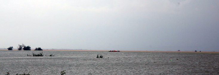 Một nhóm người dùng thuyền vượt phá Hạc Hải để vào trong các vùng lũ lụt ngập sâu