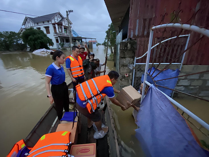 Đại diện Công đoàn cơ sở BIDV Quảng Bình trao hỗ trợ cho các hộ dân bị ngập lụt nặng tại huyện Lệ Thủy