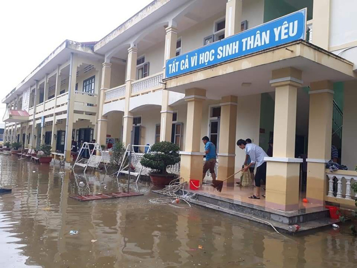 Giáo viên các trường trên địa bàn huyện Quảng Ninh tranh thủ nước lũ rút đến đâu vệ sinh trường lớp đến đó.