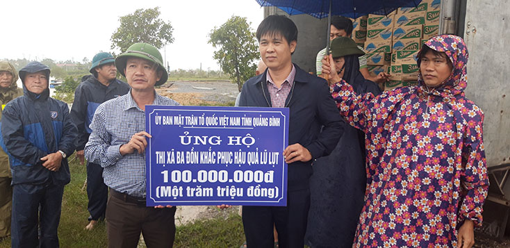 Đại diện lãnh đạo Ủy ban MTTQVN tỉnh trao hỗ trợ 100 triệu đồng cho người dân vùng lũ thị xã Ba Đồn